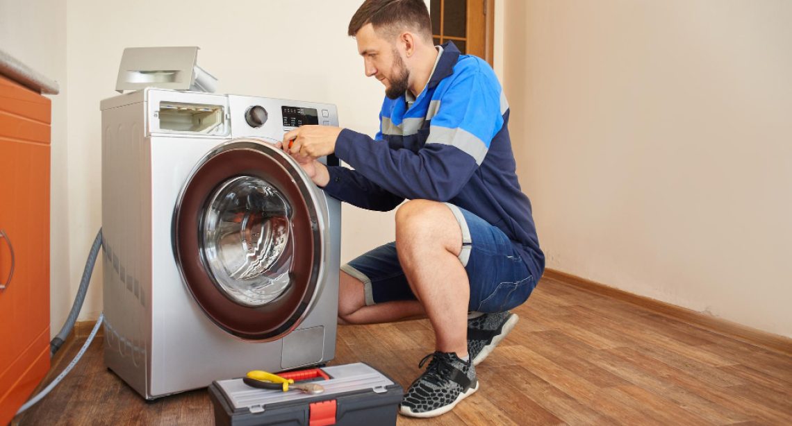 plumber-overalls-with-tools-is-repairing-washing-machine-house